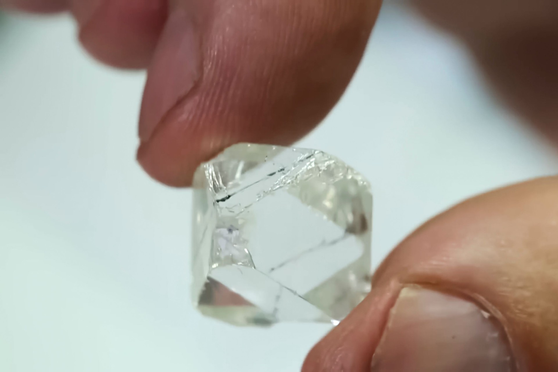 Rough diamond in the fingers of a mans hand